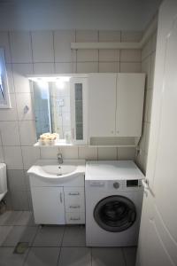 a white bathroom with a washing machine and a sink at Estia's House in Ágios Prokópios