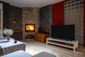 uma sala de estar com televisão e lareira em Villa Luxury Rock Tirri em Reus