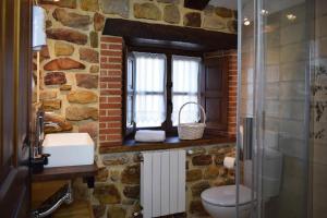 a stone bathroom with a toilet and a window at Casa Rural Los Riveros de Jeromo in Selaya