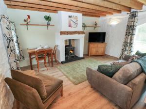 ein Wohnzimmer mit einem Sofa und einem Kamin in der Unterkunft Abaty Cottage in Haverfordwest
