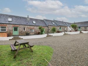 a picnic bench in front of a row of buildings at Abaty Cottage in Haverfordwest