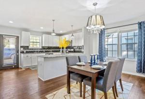 a dining room with a table and chairs and a kitchen at Modern 3BD Cottage Home w/Private HotTub in Atlanta