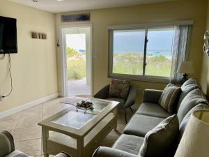 uma sala de estar com um sofá e uma mesa de centro em Beach Front Villa - Right On The Beach! em Holmes Beach