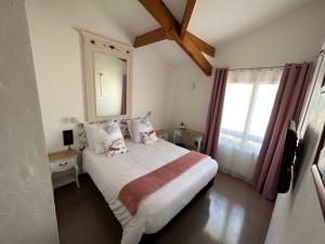 Un dormitorio con una cama grande y una ventana en Logis Hotel De La Clape, en Narbonne-Plage