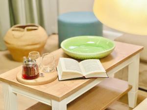 a table with a book and a bowl and glasses at Appartements "Zum Leuchtturm" Hafen Rankwitz Insel Usedom in Rankwitz