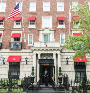 un homme debout à l'entrée d'un bâtiment dans l'établissement The Eliot Hotel, à Boston