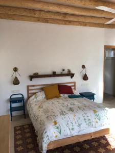 a bedroom with a large bed with a wooden headboard at Milagro de Algar in Vejer de la Frontera