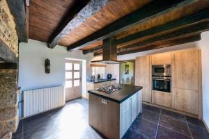 a kitchen with wooden ceilings and a stove top oven at Domaine des Grands Bois Privatisé in Sergeac