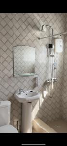 uma casa de banho com um lavatório, um WC e um espelho. em Queen's Hill Lodge em Oblogo
