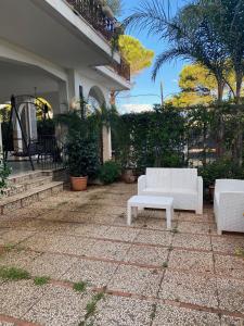 a patio with two white couches on a house at Holiday & House - Imparato Carini Costa Verde in Carini