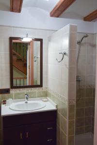 a bathroom with a sink and a shower and a mirror at Casa Rural Martín in Tronchón