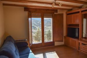 a living room with a couch and a large window at Casa Rural Martín in Tronchón