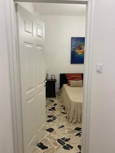 a white door leading to a bedroom with a bed at Holiday & House - Imparato Carini Costa Verde in Carini