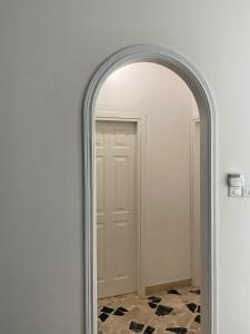 an archway mirror in a hallway with a door at Holiday & House - Imparato Carini Costa Verde in Carini