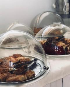 a table with three plates of food in glass domes at Elafonisos Mare in Elafonisos