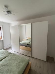 1 dormitorio con cama y espejo grande en Schöne 2-Zi-Whg, sehr gut ausgestattet, en Hemmingen
