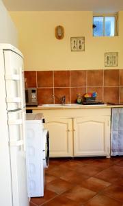 uma cozinha com um frigorífico branco e um lavatório em La Maison Verte em Tulette