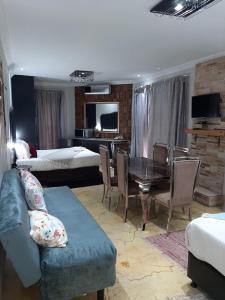 sala de estar con sofá, mesa y cama en Lodge Bellagio, en Mthatha
