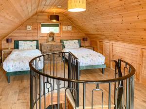 1 dormitorio con 2 camas en una cabaña de madera en Chalet 2, en Torcastle