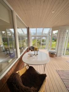 a room with a table and chairs on a porch at Værelse med udsigt over Limfjorden - rolige omgivelser og adgang til flot have in Nykøbing Mors