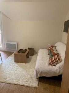 a bedroom with a bed and a coffee table at La Poudreuse Résidence les Balcons d'Aix in La Féclaz