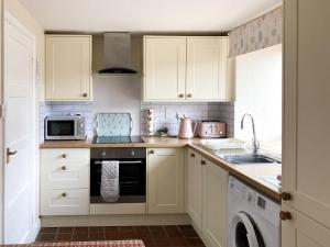 a kitchen with white cabinets and a sink and a microwave at Westerley Uk31573 in Clifford