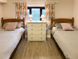a bedroom with two beds and a dresser with two lamps at Westerley Uk31573 in Clifford
