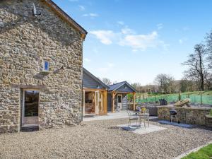 an external view of a stone house with a patio at The Mill in Llandegley
