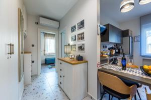 cocina con armarios blancos y encimera en Sylvia suite@Kantrida en Rijeka