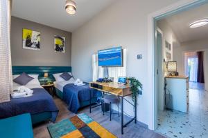 a hotel room with two beds and a desk at Sylvia suite@Kantrida in Rijeka