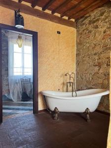 a bath tub in a room with a stone wall at Corte Dei Folletti in Lucca