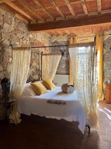 a bedroom with a bed with white sheets and curtains at Corte Dei Folletti in Lucca