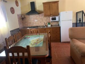 eine Küche mit einem Tisch und einem weißen Kühlschrank in der Unterkunft Casa Rural Cortijo El Helao in Pozo Alcón + 57 Fotos