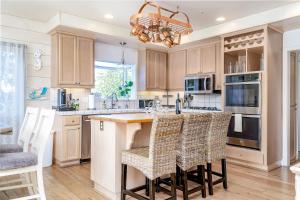 a kitchen with wooden cabinets and a island with bar stools at Hilltop Heaven in Atascadero