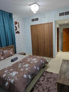 a bedroom with a bed and a wooden cabinet at Diamond Room in Shared Apartment in Ajman 
