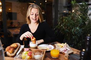 une femme assise à une table mangeant de la nourriture dans l'établissement Madrigal, à Paris