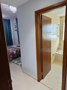 a bathroom with a glass door with a shower and a sink at Diamond Room in Shared Apartment in Ajman 