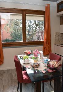 a dining room table with two chairs and two windows at B&B Cava Rossa in Monsummano