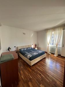 1 dormitorio con 1 cama y suelo de madera en Casa Lella, en Dervio