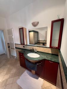 baño con lavabo y espejo grande en Casa Lella, en Dervio