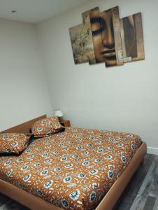 Cama en habitación con pinturas en la pared en Maison classée 2 étoiles en plein cœur de Margaux en Margaux