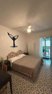 um quarto com uma cama com uma baleia na parede em Curpi de Ma em Bonassola