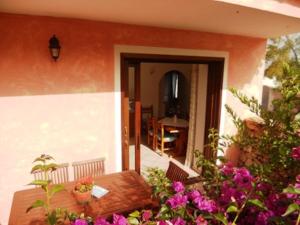 un porche de una casa con una mesa y flores en Villa Maestrale, en Olbia