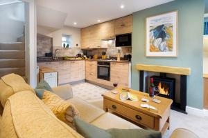 a living room with a couch and a fireplace at The Snug 'Keswick' in Keswick