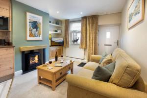 a living room with a couch and a fireplace at The Snug 'Keswick' in Keswick