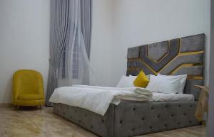 a bedroom with a bed and a yellow chair at Luxury 1 Bedroom & Parlor Service Apartment with beautiful Amenities in Awoyaya