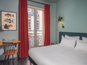 sypialnia z łóżkiem i oknem z czerwonymi zasłonami w obiekcie Hôtel Edgar & Achille w Paryżu