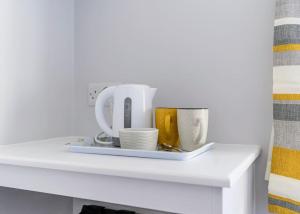 a white shelf with a plate with dishes on it at Burrows Lodge in Waterford