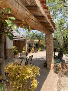 eine Terrasse mit einem Tisch und Stühlen unter einer hölzernen Pergola in der Unterkunft Casa Rural Cortijo El Helao in Pozo Alcón