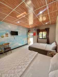 a bedroom with two beds and a tv on the wall at Quang Vinh Hồ Tràm in Ho Tram +31 photos